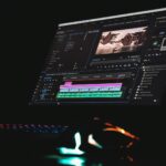 black laptop computer turned on displaying music player