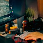 Hands typing on keyboard near computer monitor